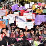 Participants displaying placards as a large women from all walks of life participating in a rally (Aurat March) to mark International Women’s Day