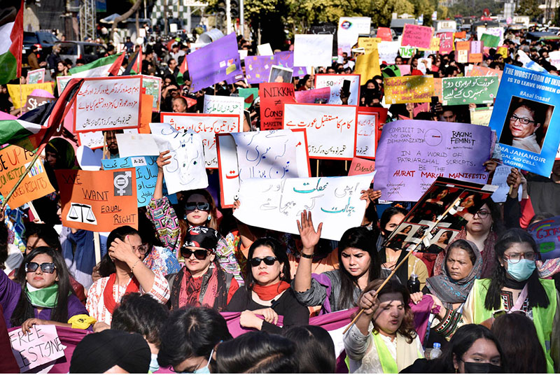 Participants displaying placards as a large women from all walks of life participating in a rally (Aurat March) to mark International Women’s Day