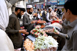 Women waiting in front of a Tandoor for free distribution of bread loaf by philanthropists at Ghanta Ghar Chowk