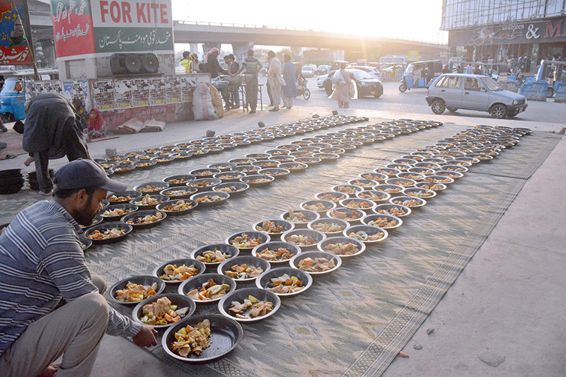 Volunteers organize Iftar for fasting people at a roadside setup arrange by philanthropists in the holy month of Ramadan