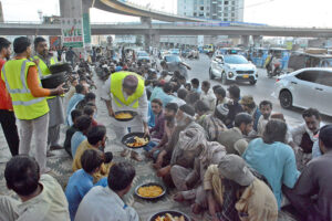 Volunteers organize Iftar for fasting people at a roadside setup arrange by philanthropists in the holy month of Ramadan