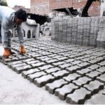 A worker prepares tuff tiles at his work place