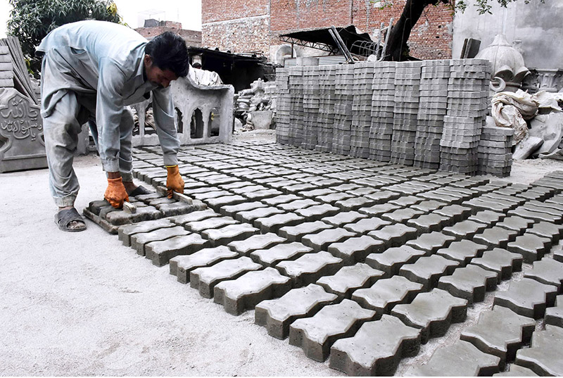 A worker prepares tuff tiles at his work place