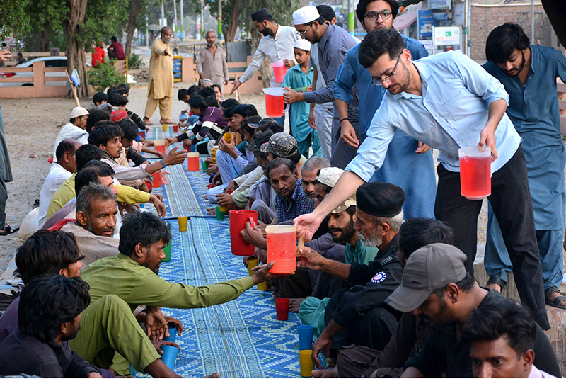 Volunteers distribute drink to peoples for Ifra during the Holy Month of Ramadan at Latifabad