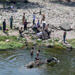 Youngsters bathing in Korang Nullah to get relief from hot weather in Federal Capital.
