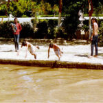 Youngsters taking bath in a canal during hot day in the city