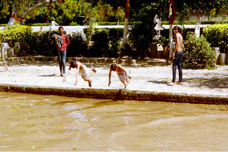 Youngsters taking bath in a canal during hot day in the city