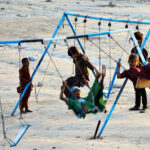 Gypsy children enjoy swings at Qasimabad.