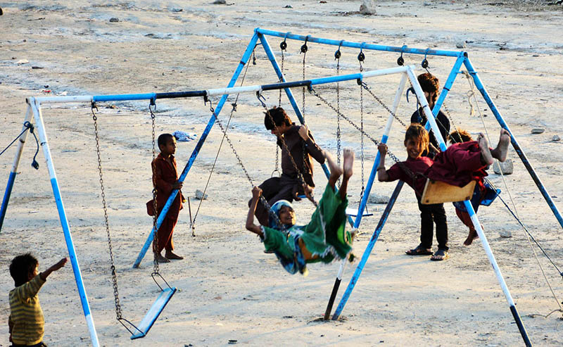 Gypsy children enjoy swings at Qasimabad.