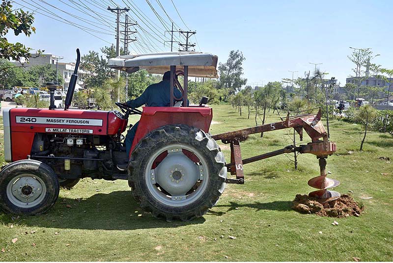 CDA workers drilling with machine for plantation in greenbelt along IJP Road.