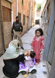Lady Health Worker administering polio drops to a child during anti polio campaign at Dalazak Road.