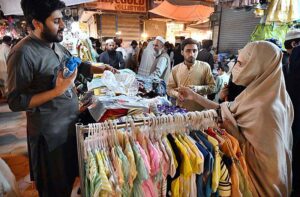 Customers selecting and purchasing children purse during Eid shopping at Gora Bazar.
