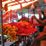 Vendor busy making flower garlands to attract customers