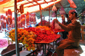Vendor busy making flower garlands to attract customers