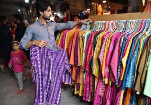 Customers selecting and purchasing children purse during Eid shopping at Gora Bazar.