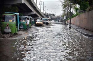 Vehicles passing through rain water accumulated on road in front of Radio Pakistan during heavy rain in the city.