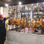 A worker preparing traditional food item Sajji to attract customers at local hotel