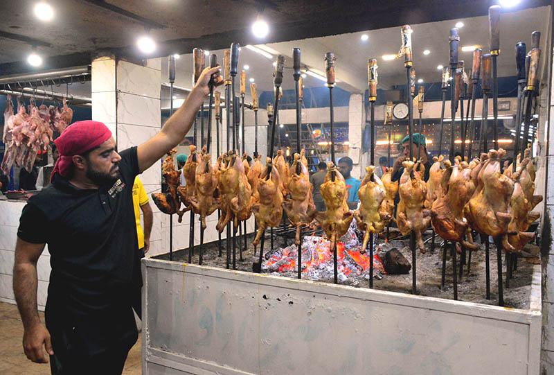 A worker preparing traditional food item Sajji to attract customers at local hotel