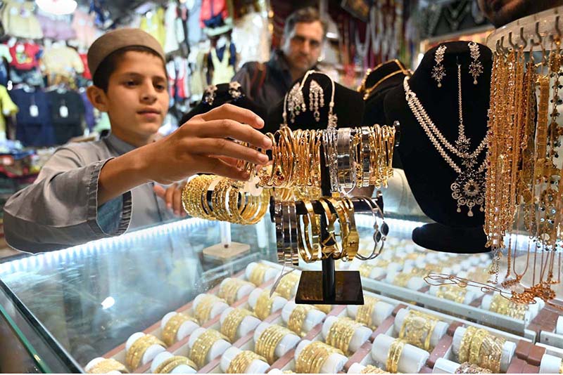 A young vendor displaying artificial jewellery to attract the customers at Sadar Bazaar connection with Eid ul Fitr.