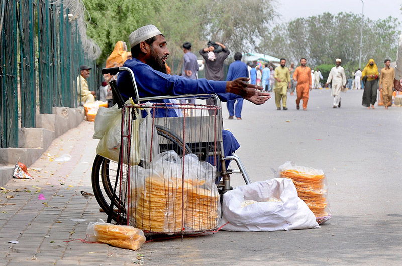 A disabled person selling food item for livelihood at a local park