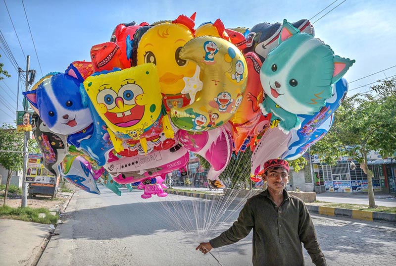 A street vendor displaying different cartoon shapes balloons to attract the customers at Ghouri Town in Federal Capital.