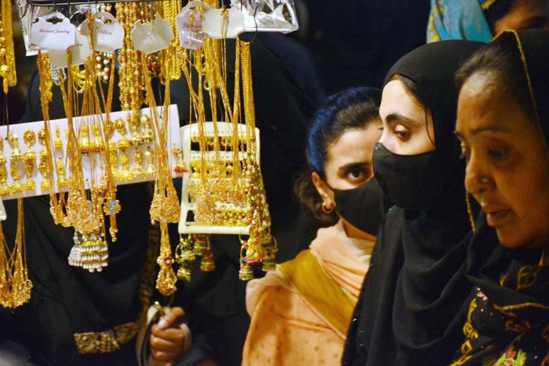 Women selecting and purchasing artificial jewelry from vendor in preparation of upcoming Eidul Fitr