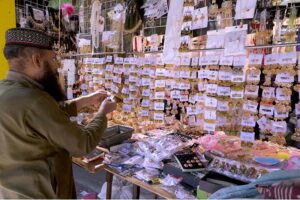 A vendor displaying artificial jewelry to attract customers at G-9 Markaz