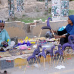 An elderly couple preparing handmade paper toys called "Ghugo Ghourray" for livelihood