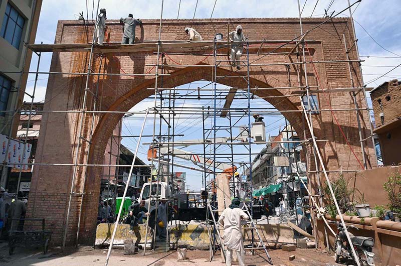 Labourers busy in renovation work of historic Qissa Khawani Bazaar Gate.