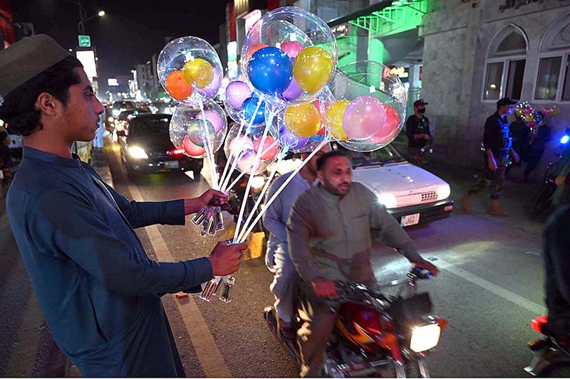 A youngster displaying colorful balloons to attract the customers at Sadar Bazaar Chowk to earn his livelihood.