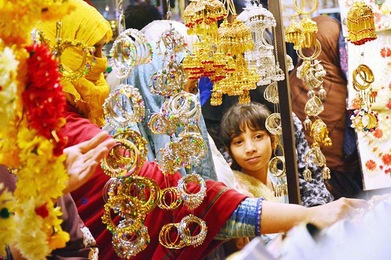 Women selecting and purchasing artificial jewelry from vendor in preparation of upcoming Eidul Fitr