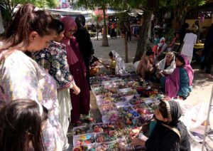A vendor displaying artificial jewelry to attract customers at G-9 Markaz