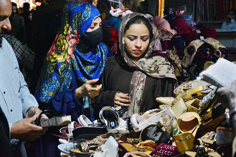 Women selecting and purchasing artificial jewelry from vendor in preparation of upcoming Eidul Fitr