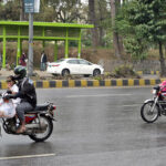 Motorcyclists on the way at Islamabad Highway during light showers that experienced the Federal Capital