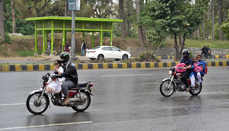 Motorcyclists on the way at Islamabad Highway during light showers that experienced the Federal Capital