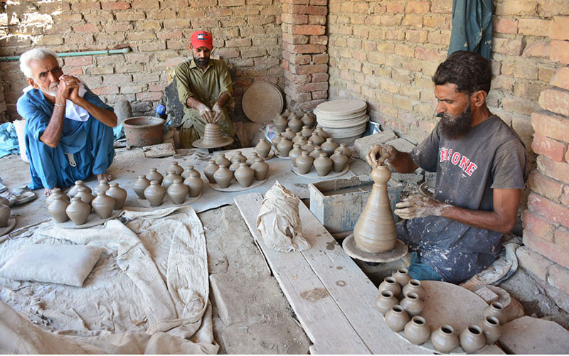 Workers busy in preparing the clay made pots at his workplace