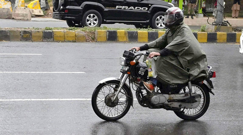 Motorcyclists on the way at Islamabad Highway during light showers that experienced the Federal Capital