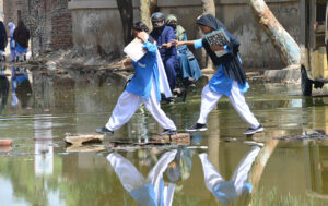 Students passing through sewerage water accumulated on the road outside Govt Girl’s high school at Latifabad.