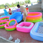 A vendor displaying the inflatable pools to attract the customers at roadside