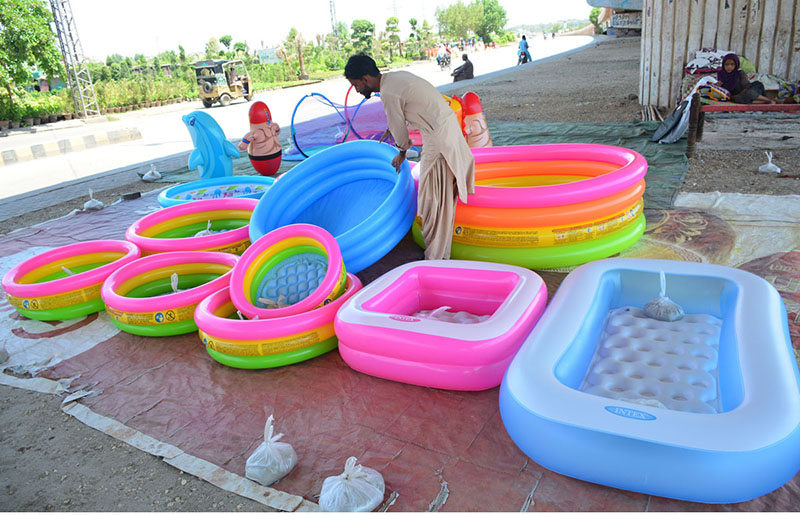 A vendor displaying the inflatable pools to attract the customers at roadside