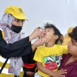 A lady health worker administering polio drops to a child during 7-days anti polio campaign in the city