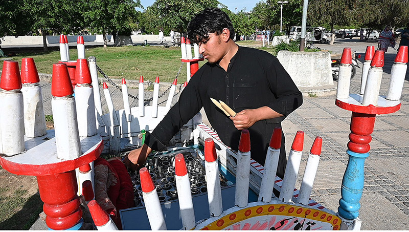 A vendor selling a traditional ice lolly (Qulfi) to attract customers outside Faisal Masjid