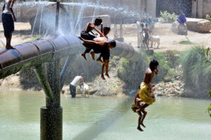 Youngsters jumping for bathing in water canal to get relief from hot weather in the city.