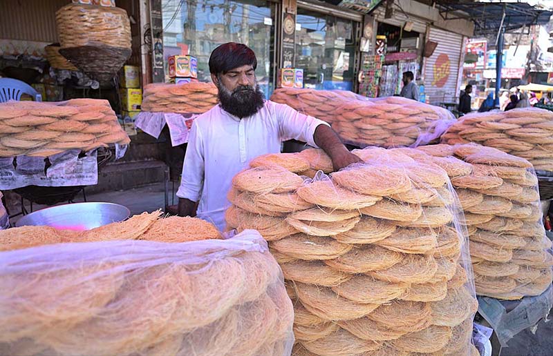 A vendor selling sweet (pheneain) on his roadside setup at Muslim Bazar.