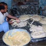 A worker preparing flour for vermicelli to be used in Eid-ul-Fitr festival