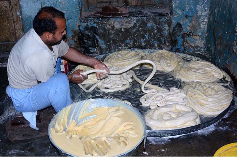 A worker preparing flour for vermicelli to be used in Eid-ul-Fitr festival