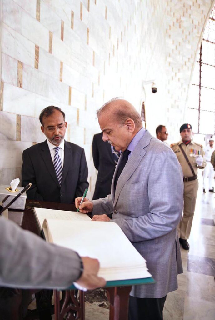 Prime Minister Muhammad Shehbaz Sharif pens down his remarks in the visitors' book at Mazar-e-Quaid.