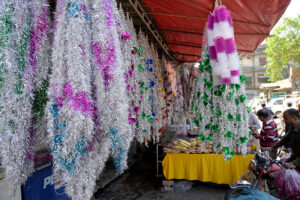 A vendor displaying garlands to attract customers at at Bani Chowk