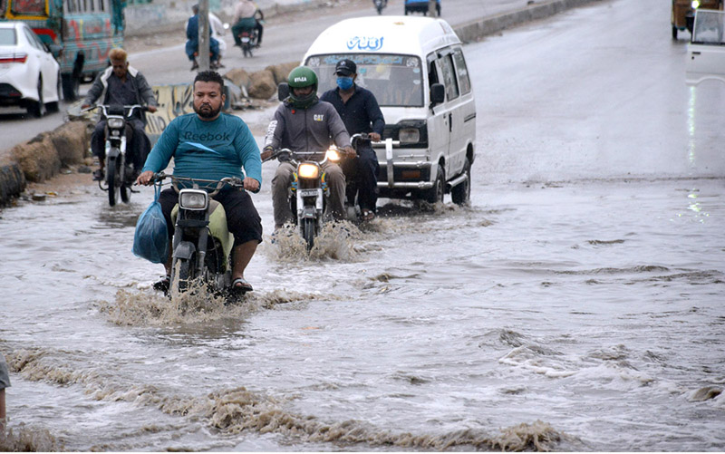 Vehicles passing through rain water at Korangi Road.