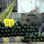 A vendor displaying and selling watermelon to attract customers at his roadside setup in the Provincial Capital